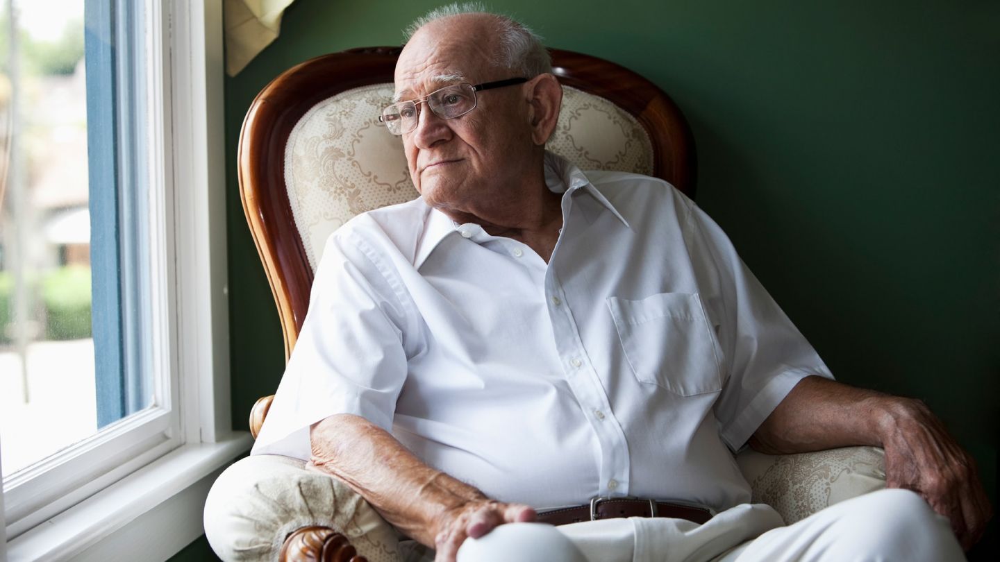 Mann mit chronischer myeloischer Leukämie (CML) (Symbolbild) (Quelle: Getty Images/kali9) Chronische myeloische Leukämie (CML): Ein älterer Mann sitzt auf einem Sessel und guckt aus dem Fenster. Er wirkt nachdenklich.