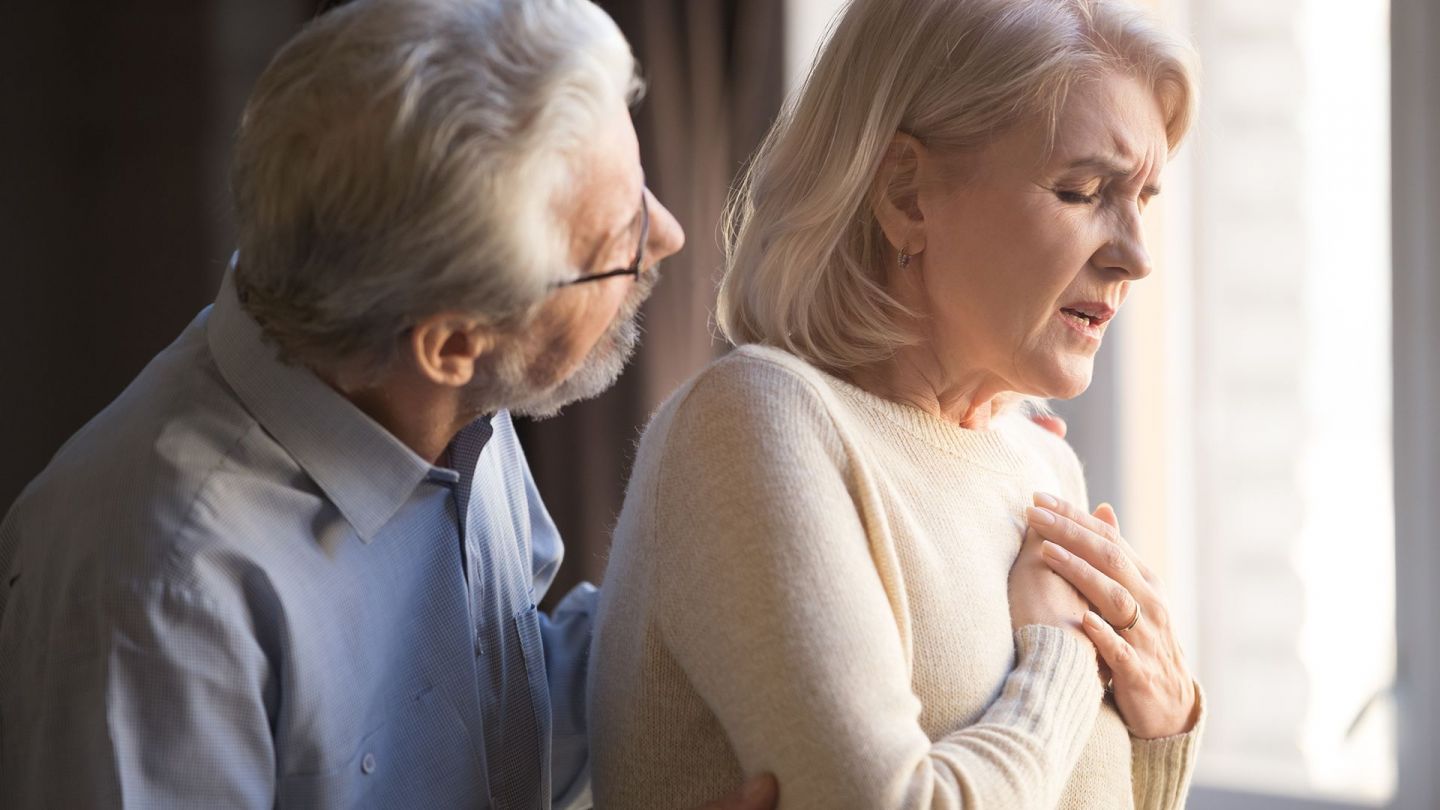 Herzrhythmus-Störung (Symbolbild) (Quelle: Getty Images/fizkes) Herzrhythmus-Störung: Eine Frau fasst sich mit beiden Händen an den Brustkorb.