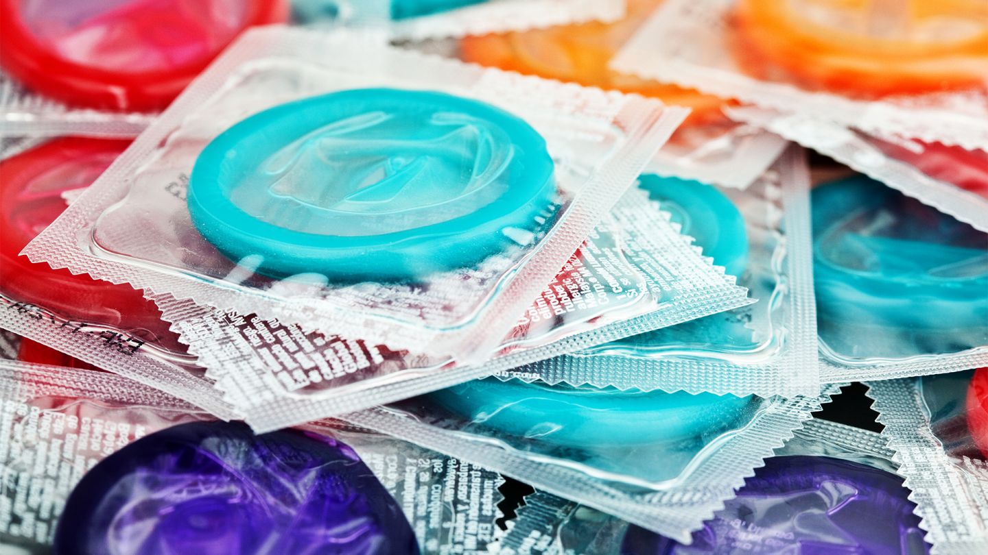 HIV Schutz HIV: Viele bunte Kondome liegen aufeinander.