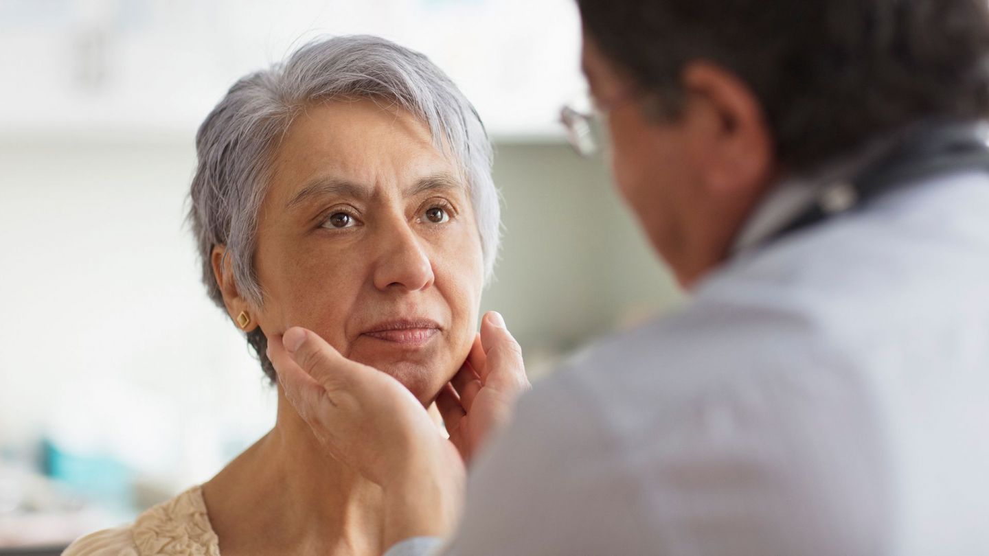 Hals Untersuchung nach Hodgkin-Lymphom (Symbolbild) (Quelle: Getty Images/Jose Luis Pelaez Inc) Hodgkin-Lymphom: Eine Frau wird von einem Arzt am oberen Hals unter dem Kinn abgetastet.