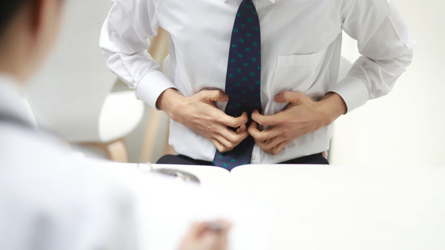 Mann mit Magenkrebs (Quelle: Getty Images/RunPhoto) Magenkrebs: Ein Mann greift sich mit beiden Händen an den Bauch. Er scheint starke Schmerzen zu haben.