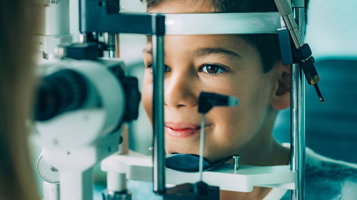 Augenuntersuchung bei Kind (Quelle: Getty Images/microgen) Schwachsichtigkeit bei Kindern: Ein Junge sitzt vor einer Spaltlampe im Behandlungsraum einer Augenarztpraxis und lässt die Sehstärke seiner Augen testen.