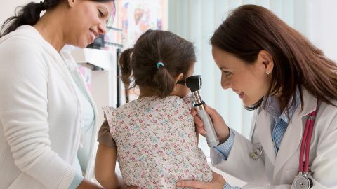 Akute Mittelohrentzündung - Diagnose (Quelle: Getty Images/SelectStock) Eine Ärztin schaut mit einem Otoskop in das Ohr eines Mädchens.