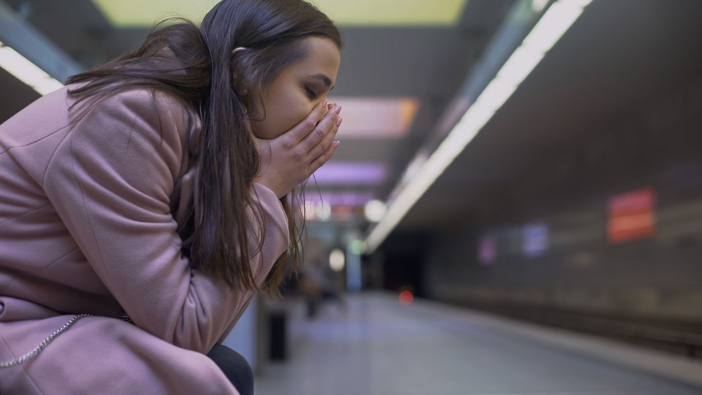 Generalisierte Angststörung (Symbolbild) (Quelle: Getty Images/Motortion) Generalisierte Angststörung: Eine Frau hat die Augen geschlossen, sitzt nach vorne gebeugt und legt ihren Kopf in beide Hände.