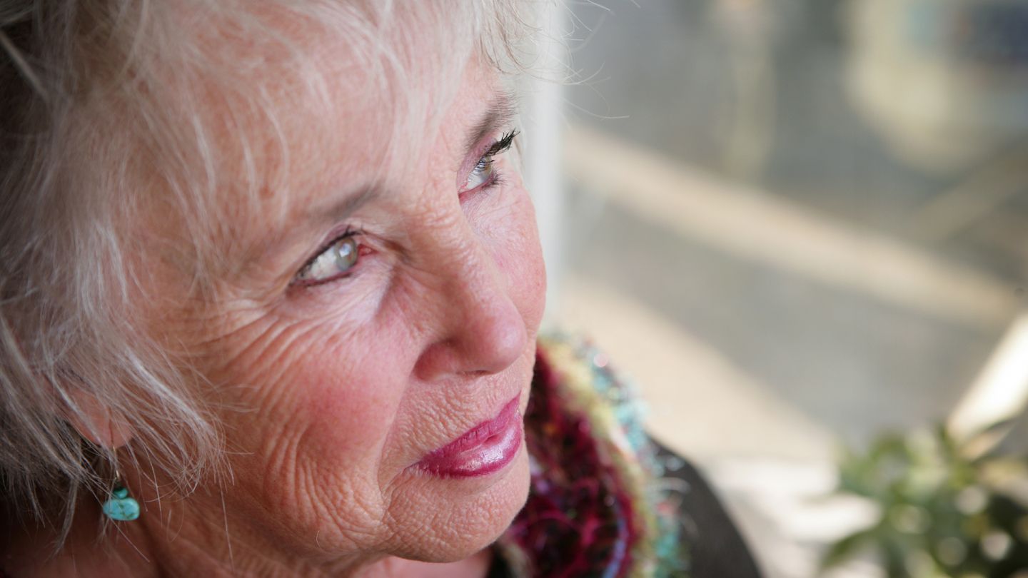 Frau mit grünblauen Augen (Quelle: Getty Images/ParkerDeen) Grauer Star (Katarakt): Eine ältere Frau mit grünblauen Augen schaut in die Ferne.