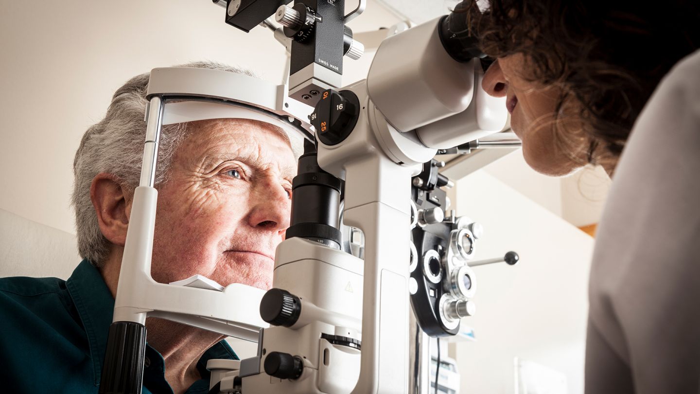Untersuchung am Auge (Quelle: Getty Images/Bill Oxford) Makuladegeneration: Ein Mann lässt seine Augen beim Optiker untersuchen.
