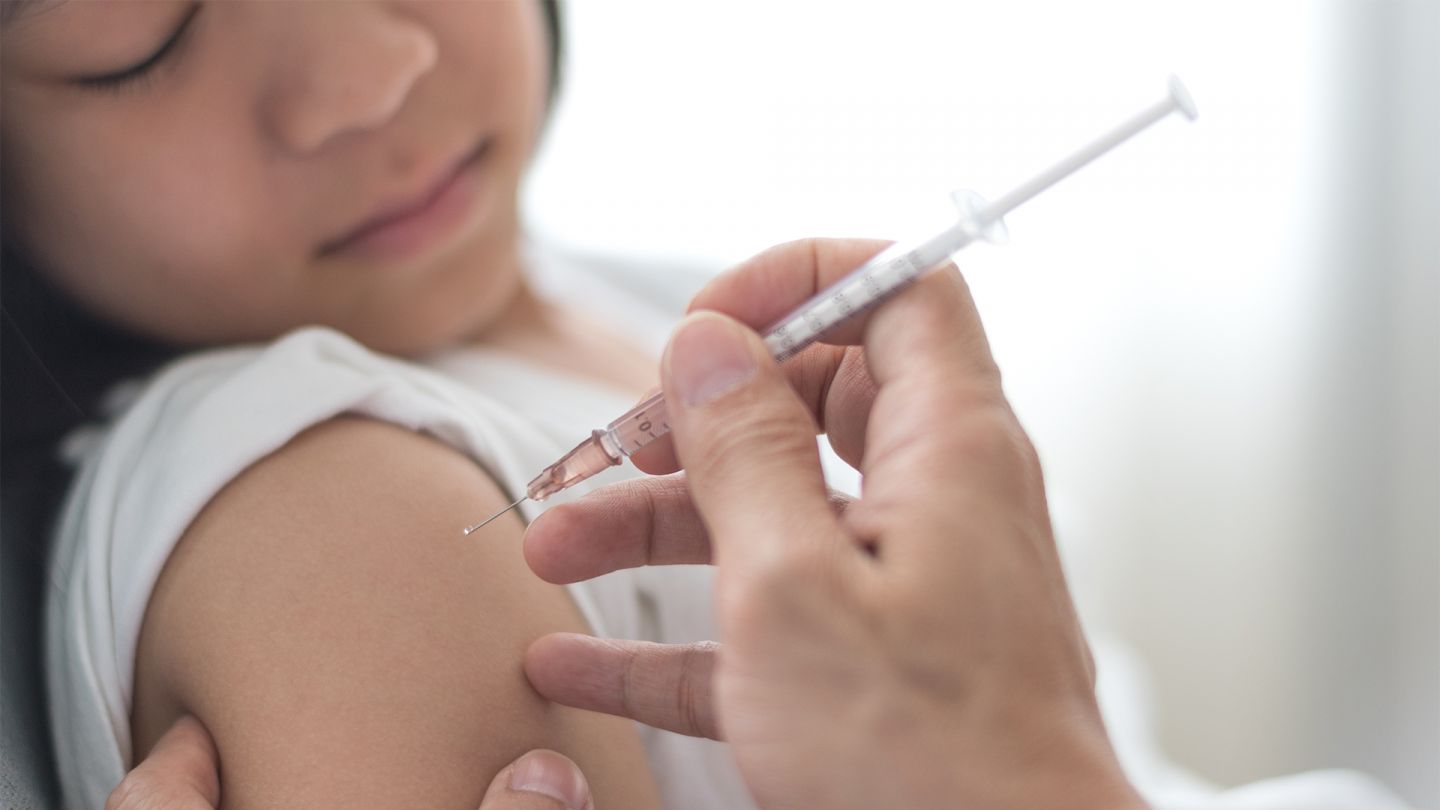 Mumps-Impfung (Quelle: Getty Images/ Pornpak Khunatorn) Mumps-Impfung: Ein Mädchen liegt auf einer Liege und bekommt eine Impfung in den Oberarm.