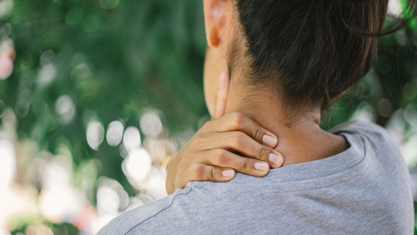 Frau mit Nackenschmerzen (Quelle: Getty Images/Anupong Thongchan / EyeEm) Nackenschmerzen: Eine Frau massiert sich ihren Nacken mit der linken Hand.