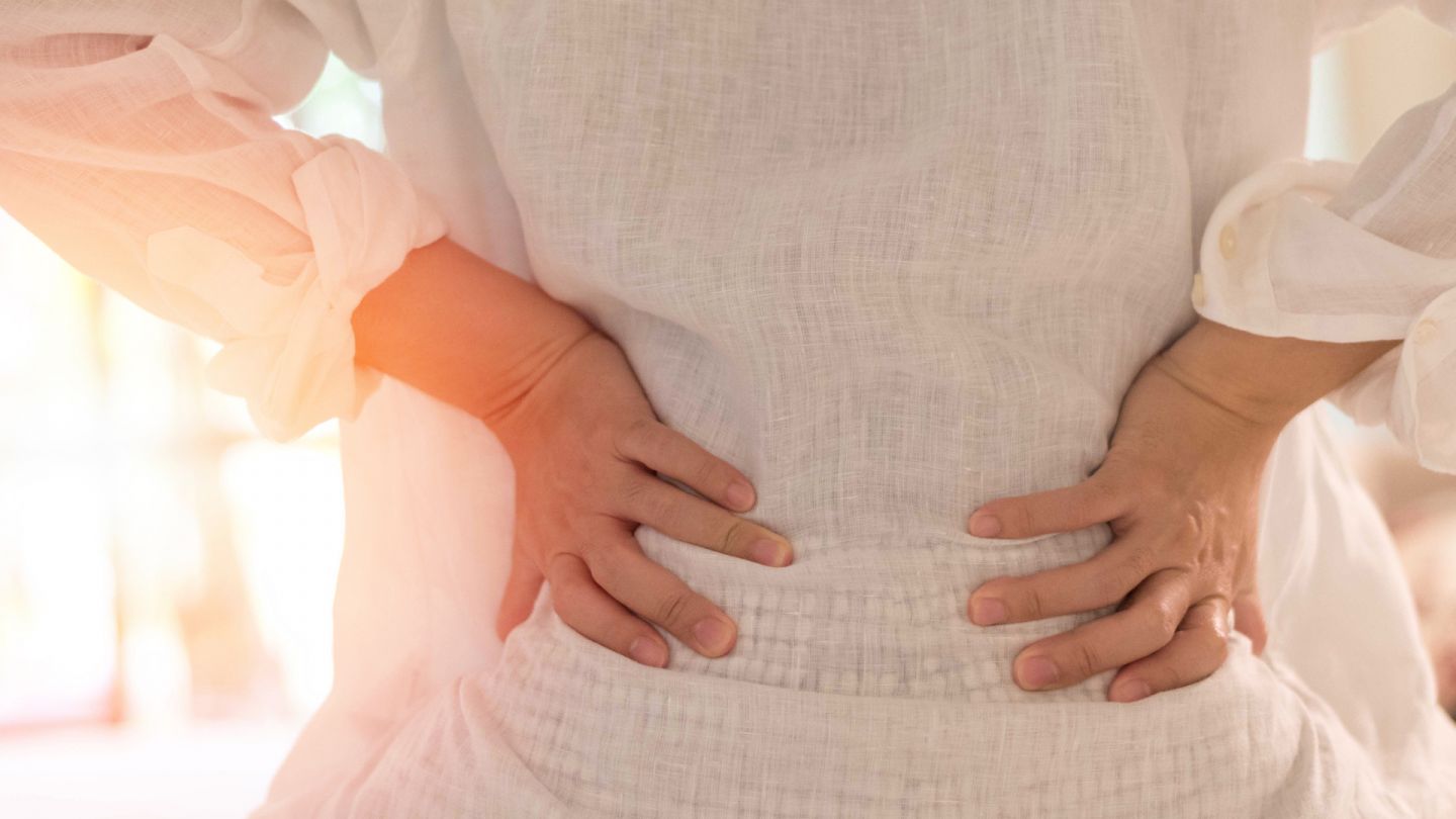Nierensteine (Quelle: Getty Images/Pornpak Khunatorn) Nierensteine und Harnleitersteine: Eine Frau legt beide Hände an die Seiten ihre Taille und beugt leicht ihren Oberkörper nach hinten.